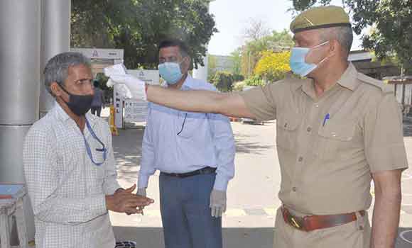 सहारनपुर में व्यक्ति की थर्मल स्केनिंग करता पुलिसकर्मी।