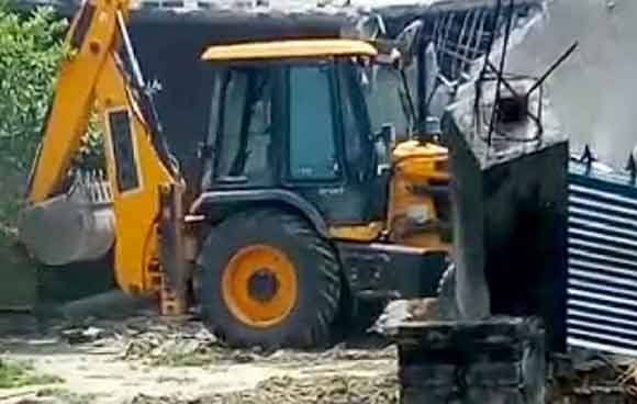 तालाब की जमीन पर अवैध रूप से कब्जा करके बनाए गये पक्के मकान को बुलडोजर ने किया ध्वस्त