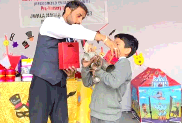 जादूगर के करतब देखकर हैराना हुए स्कूली बच्चे