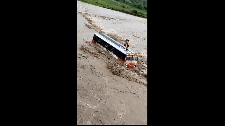 उफनती नदी की बीच धारा फंसी यात्रियों से भरी बस, पानी बहाव देख लोगों के उड़े होश…वीडियो वायरल